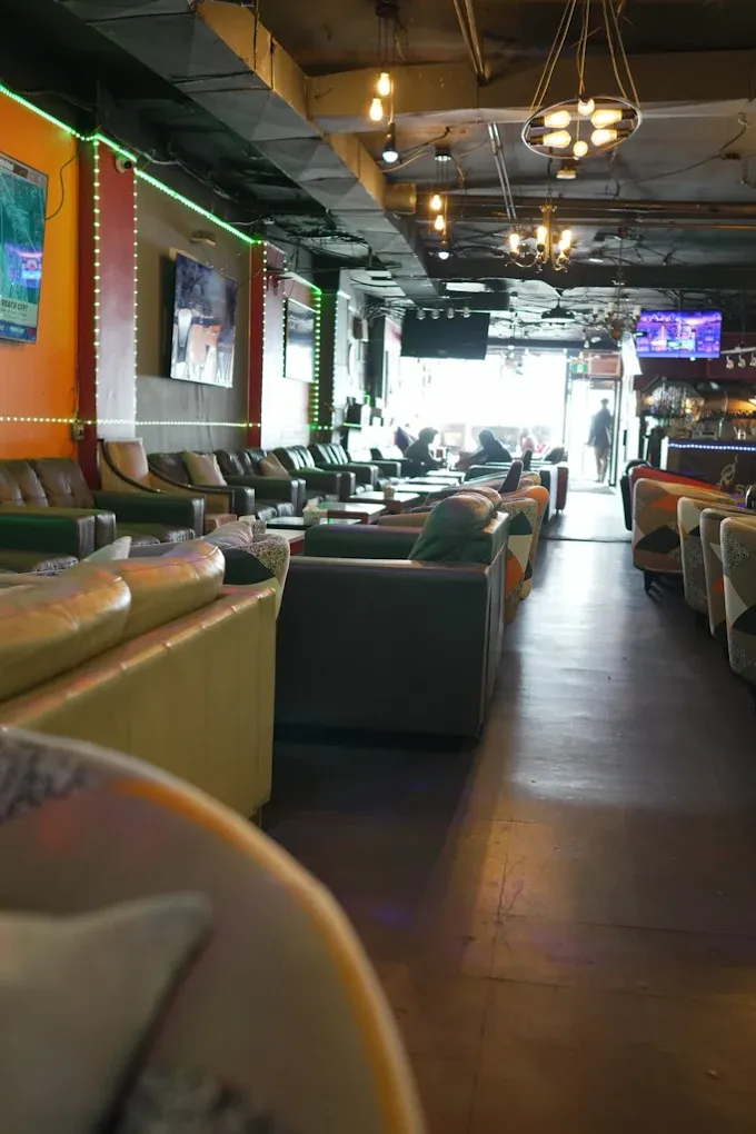 The main lounge at Dose Shisha on Danforth Ave — green LED strips, sports TVs and rows of sofas